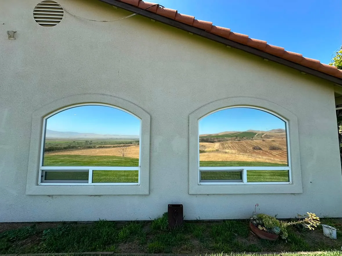 Two arched home windows with reflective residential window film
